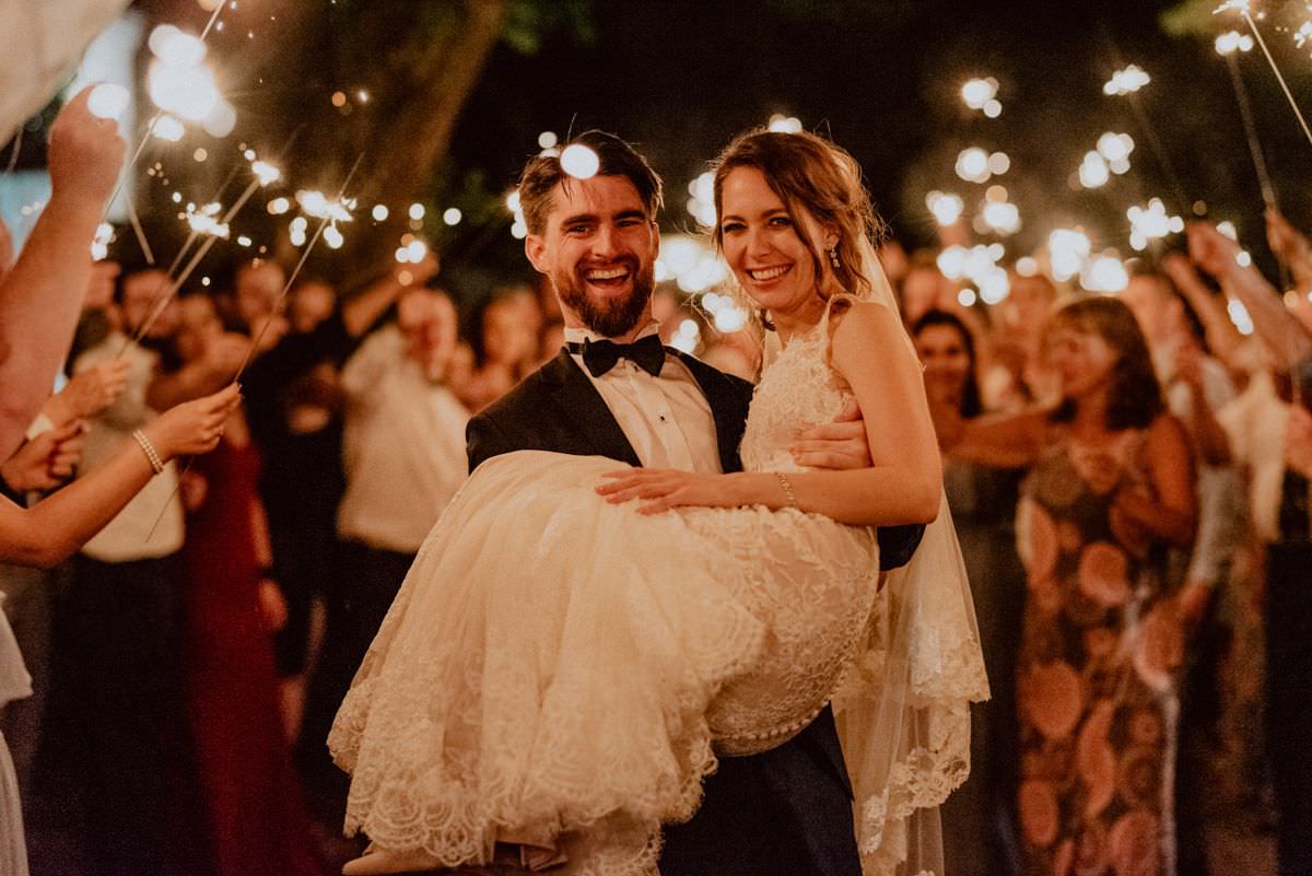 groom holds wife on his hands and people around them holds the light sticks