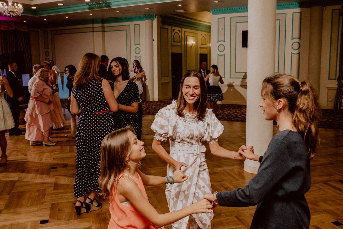 woman with children dance in circle on wedding party